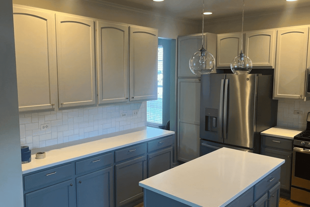 Two-tone kitchen with cream upper cabinets, blue lower cabinets, white subway tile backsplash, and stainless steel appliances