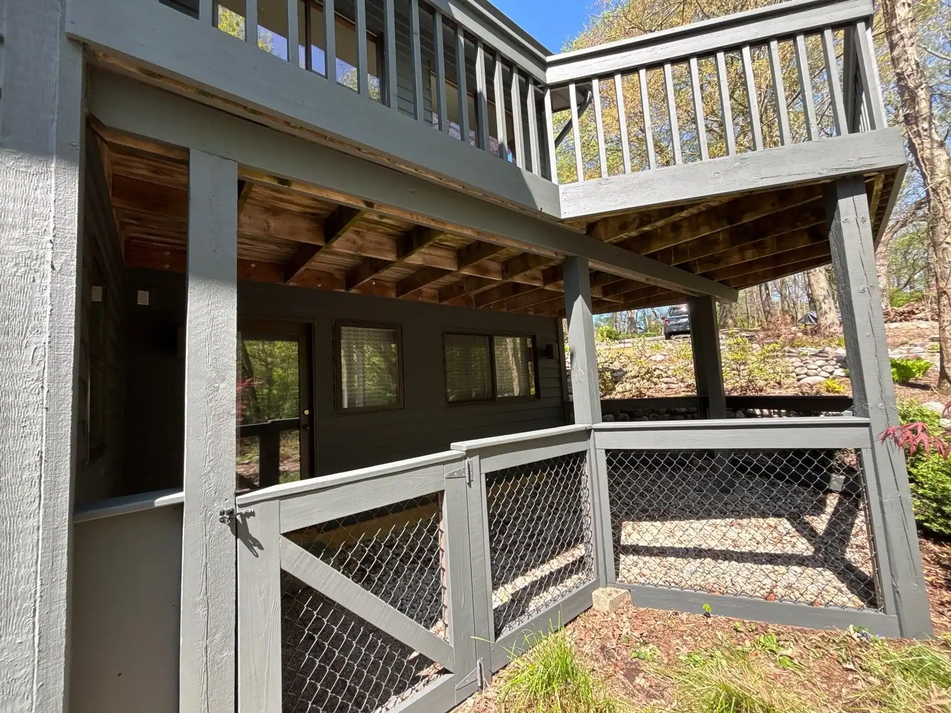 Gray Painted Residential Deck Addition Gray-painted two-level residential deck addition with white metal railing, black-framed windows, and natural wood ceiling in