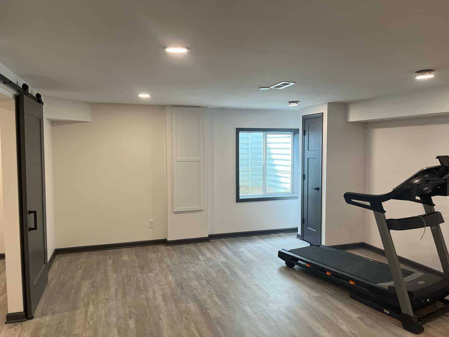 Cream Painted Commercial Fitness Room Cream-painted commercial interior with light wood-look flooring, recessed ceiling lights, and black treadmill equipment