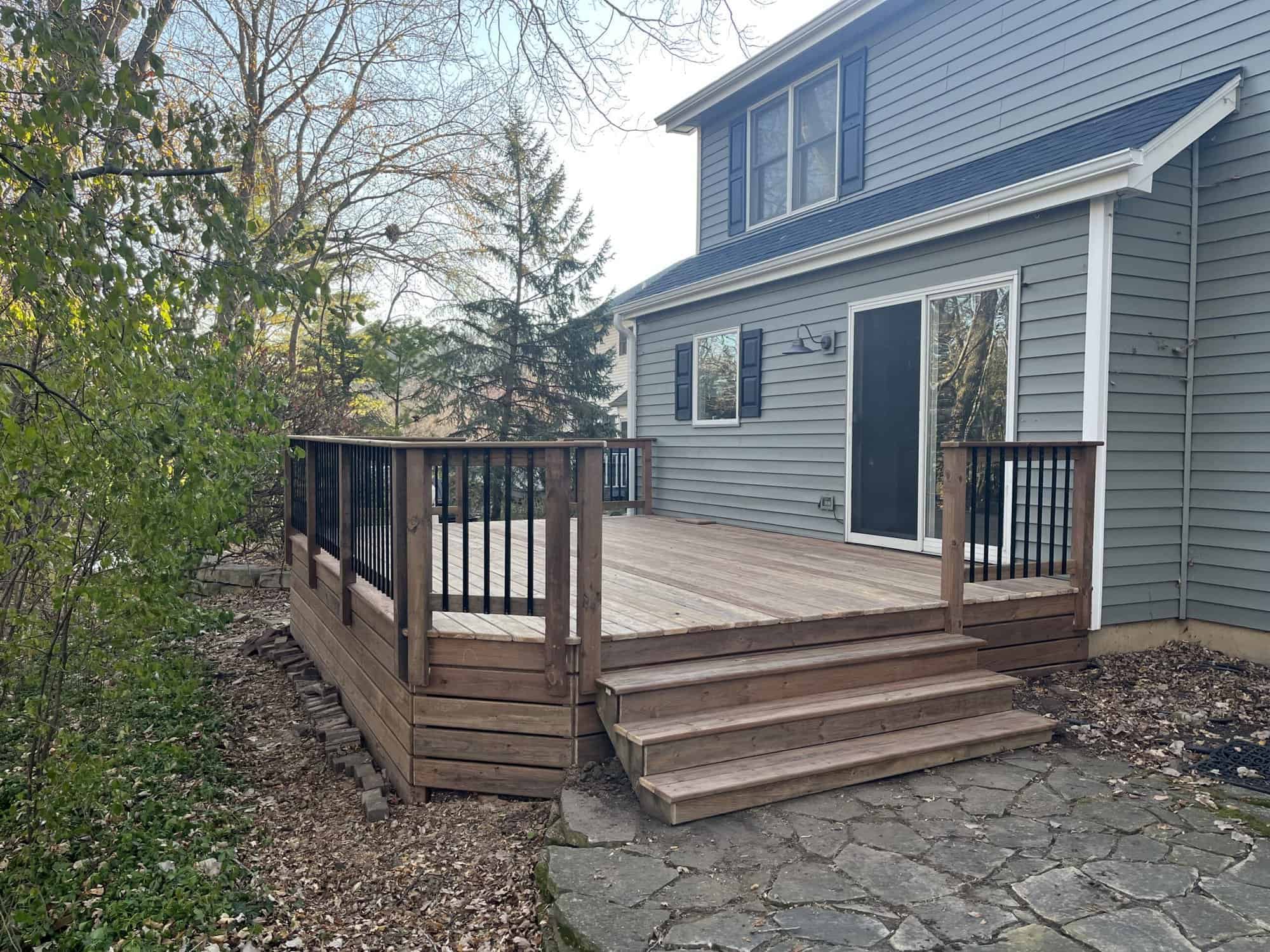 Exterior Residential Home Painting Light blue two-story residential home exterior with white trim, horizontal siding, brown composite deck with black railings