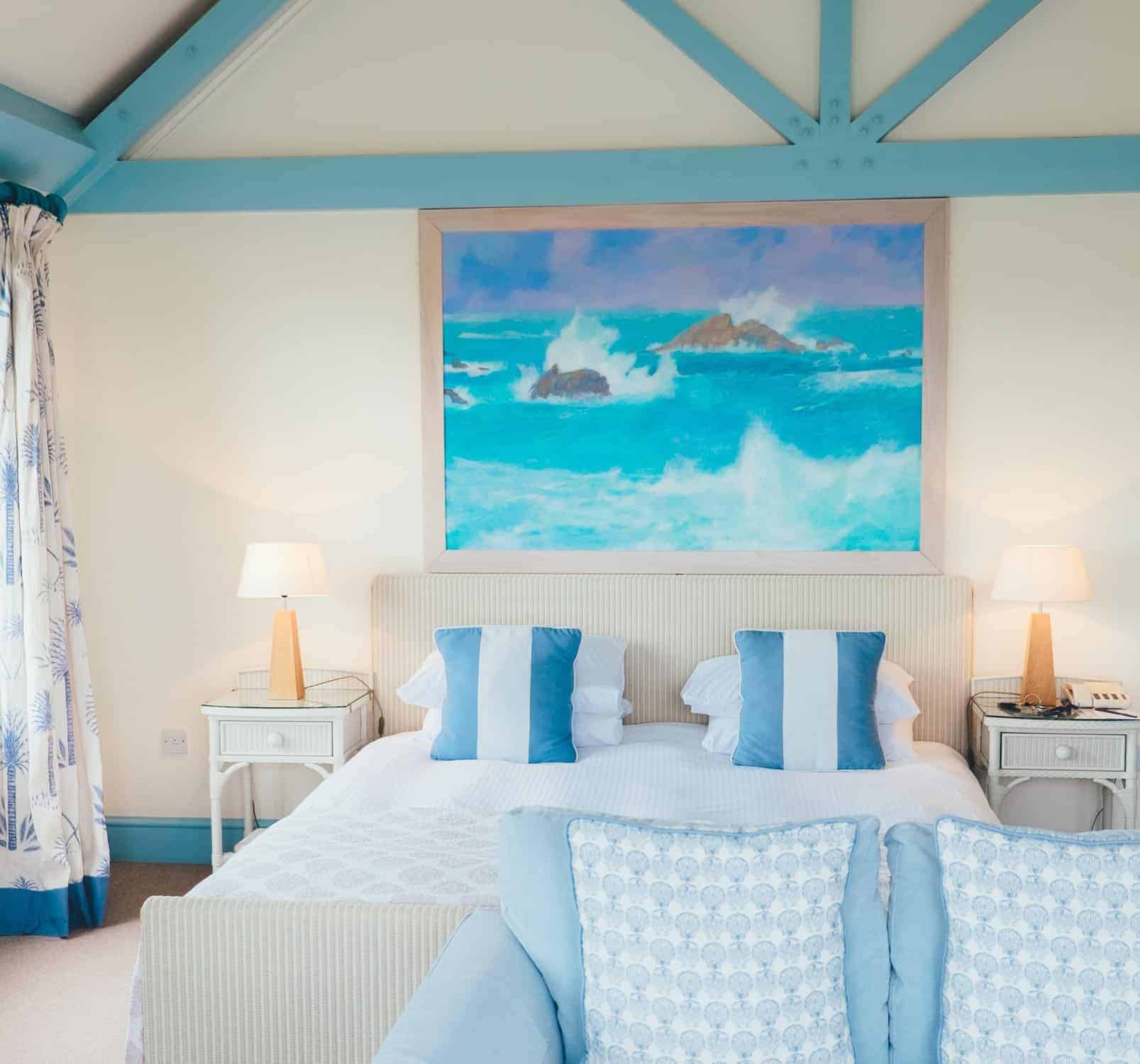 Turquoise Beam Bedroom Interior Cream-painted residential bedroom with turquoise exposed beams, white trim, and coastal ocean artwork above bed.