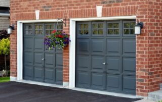 Dark gray painted garage doors with white trim on red brick residential exterior in Saint Charles, IL