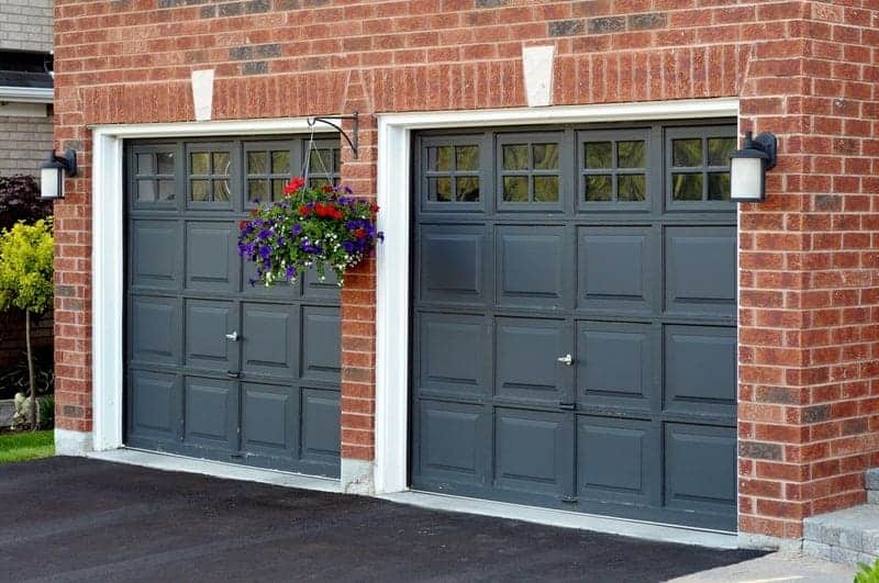 Exterior Residential Garage Doors Dark gray painted garage doors with white trim on red brick residential exterior in Saint Charles, IL