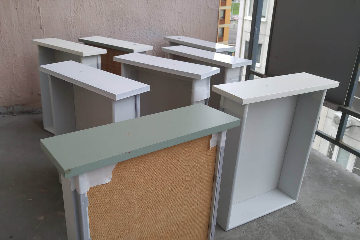 White Painted Commercial Counter Displays White-painted commercial countertop units with sage green and cork panel accents in interior commercial space.