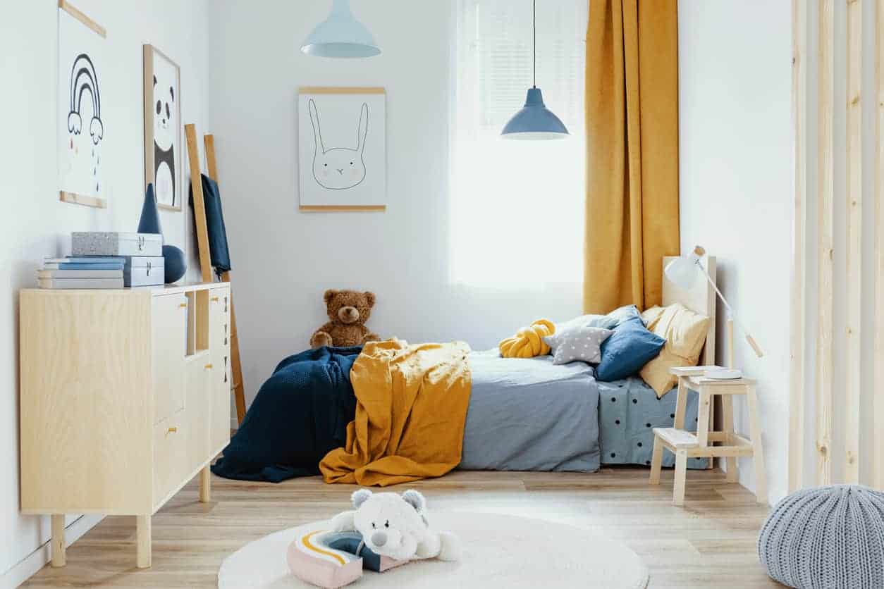 White Painted Kids Bedroom White-painted residential child's bedroom with light wood flooring, natural wood furniture, blue and yellow bedding, and