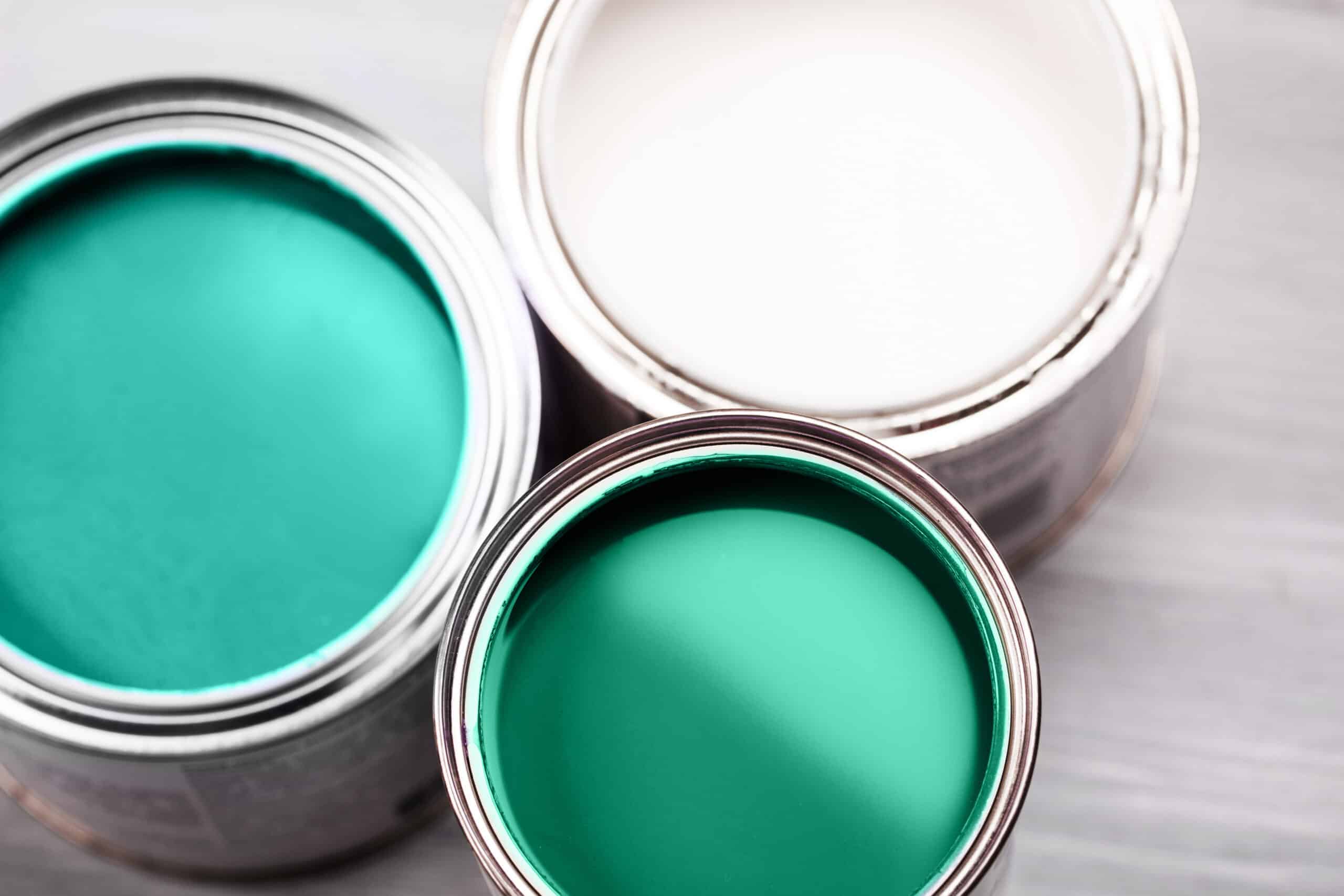 Turquoise and White Paint Color Swatches Turquoise and white paint color swatches in open cans with metallic rims on neutral surface.