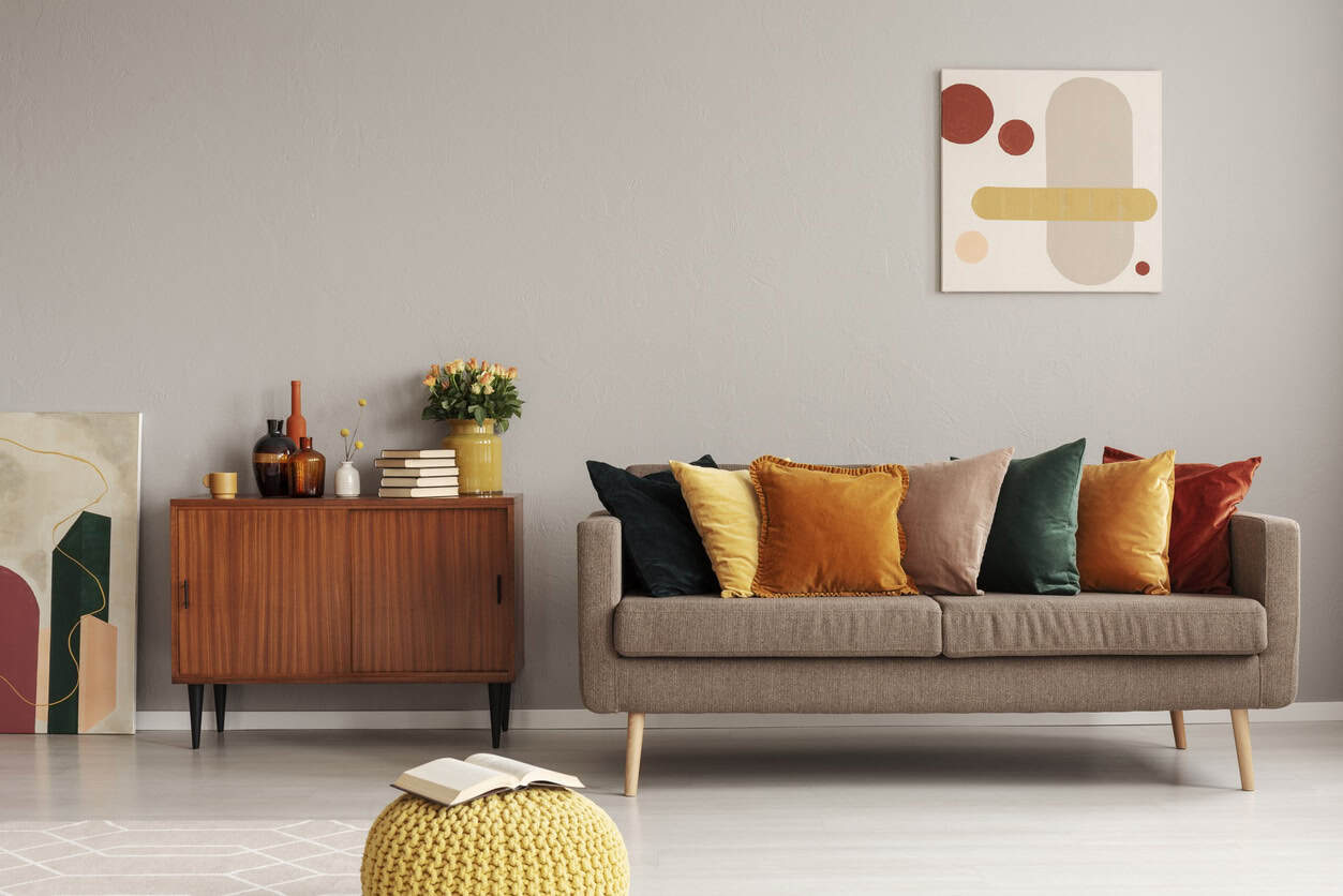 Taupe Living Room Interior Paint Taupe-painted residential living room with cream sofa, warm wood sideboard, and modern abstract wall art.