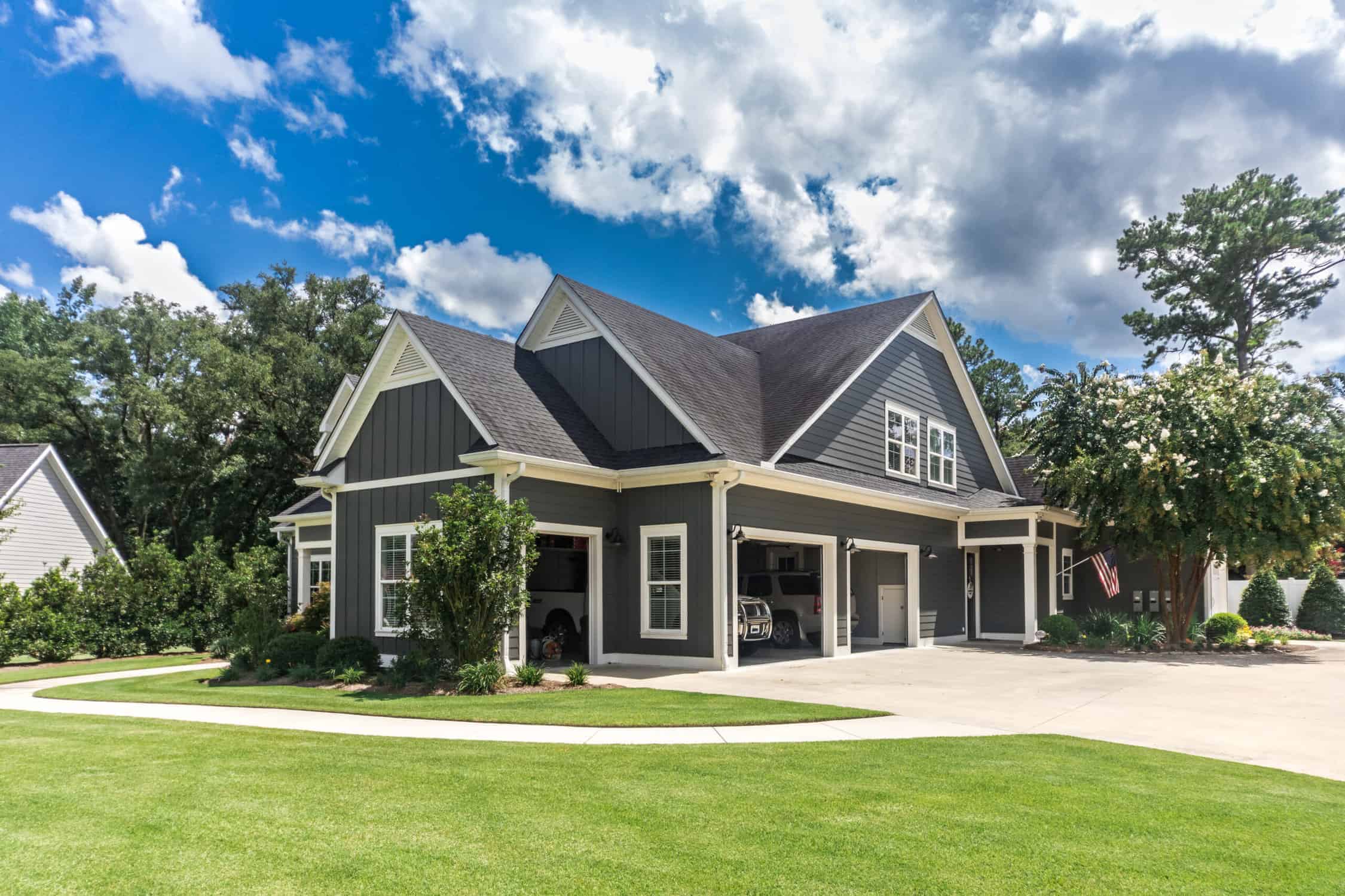 Charcoal and Cream Residential Exterior Charcoal-painted two-story residential home with cream trim, white-framed windows, and covered front porch.