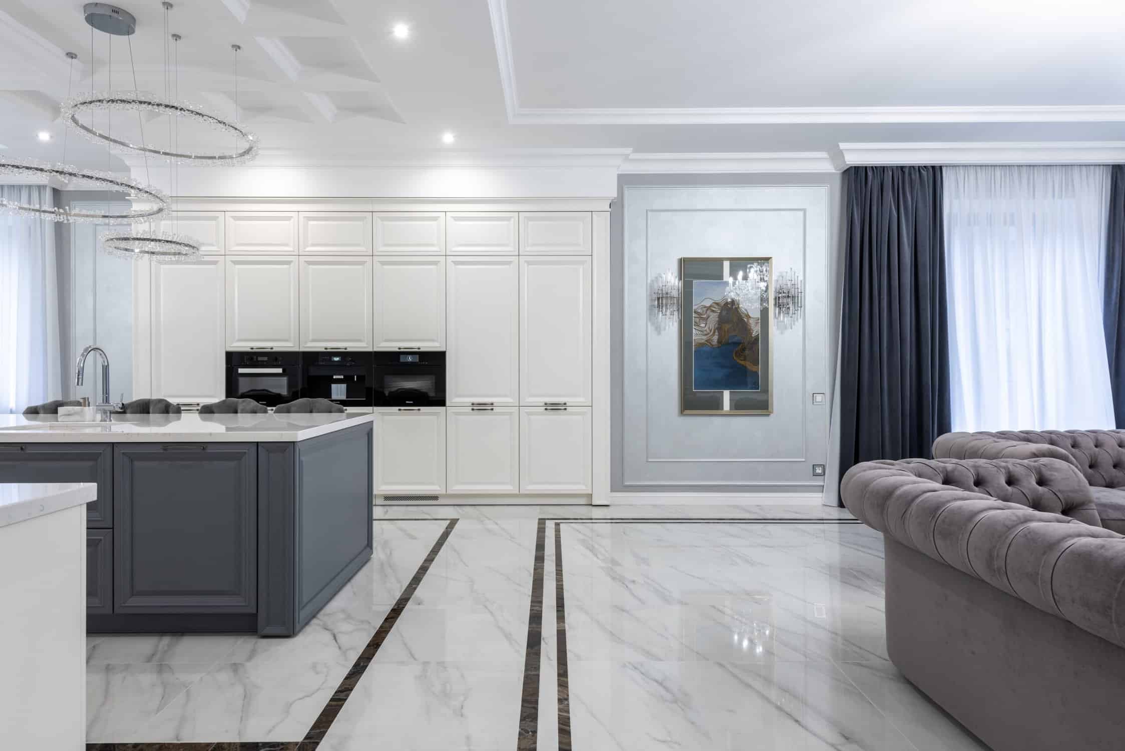 Modern Commercial Interior Kitchen Modern commercial interior with white-painted cabinetry, charcoal island base, marble flooring with dark inlay, and gray